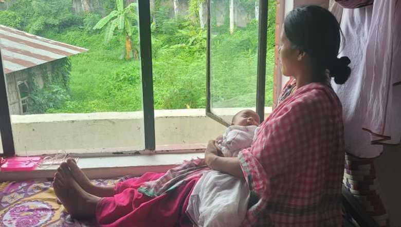 A displaced mother cradles her 24-day-old daughter in her arms as she gazes out of the window at a relief camp, yearning for peace to be restored soon (PHOTO: B Rakesh Sharma_IFP)