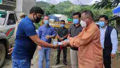 Health Minister Jayantakumar Singh (R) hands over medical kits for truck drivers at Keithelmanbi along the Imphal-Jiribam road on August 17, 2020