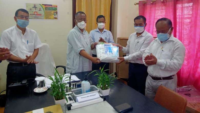 Health Minister L Jayantakumar Singh receiving PPEs from Romi Bag Industry proprietor (PHOTO: IFP)