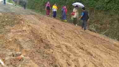 People struggle to pass through a damaged road in Tamenglong town (PHOTO IFP)